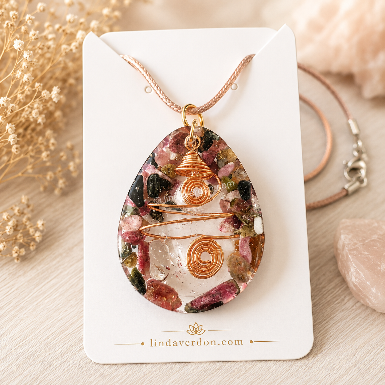 Création artisanale unique en résine époxy renfermant un cristal de roche, entouré de véritables éclats de rhodonite et sublimé par un fil d'or intégré à la création. Chaque pendentif est préparé selon notre démarche vibratoire et livré avec son cordon.