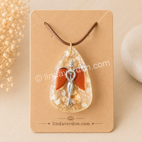 Découvrez ce pendentif Ange Gardien en citrine, jaspe rouge et cristal de roche. Une création artisanale unique en résine époxy, préparée avec soin dans l'atelier Linda Verdon.