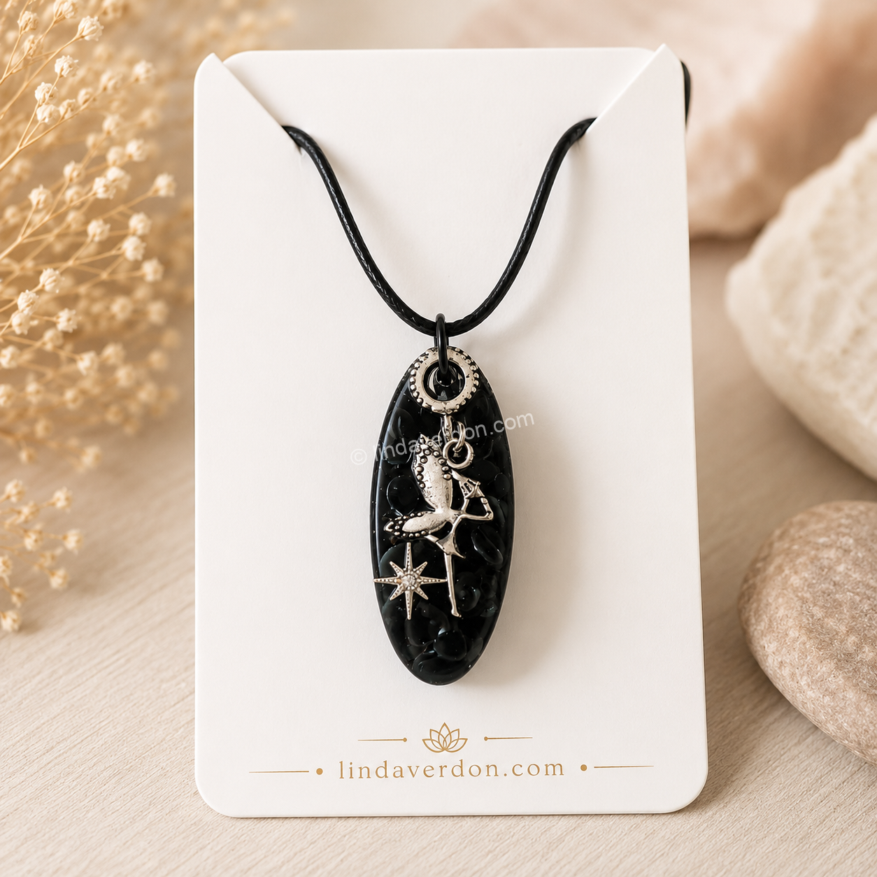 Découvrez ce pendentif en obsidienne noire avec fée argentée, réalisé à la main en résine époxy. Une création artisanale unique préparée avec soin dans l'univers de Linda Verdon.