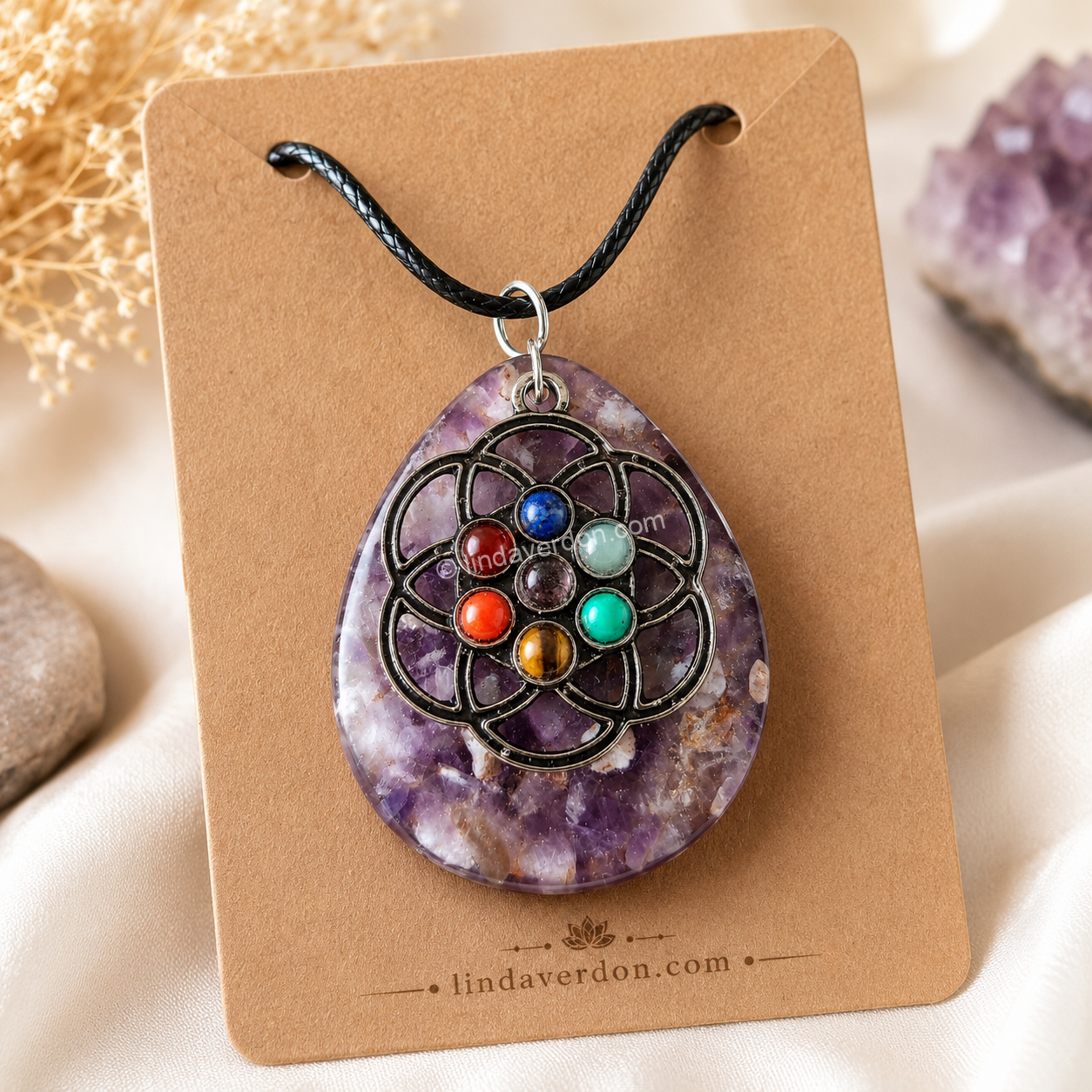 Découvrez ce pendentif Fleur de Vie en améthyste avec les 7 pierres des chakras. Une création artisanale unique en résine époxy, préparée avec soin dans l'atelier Linda Verdon.