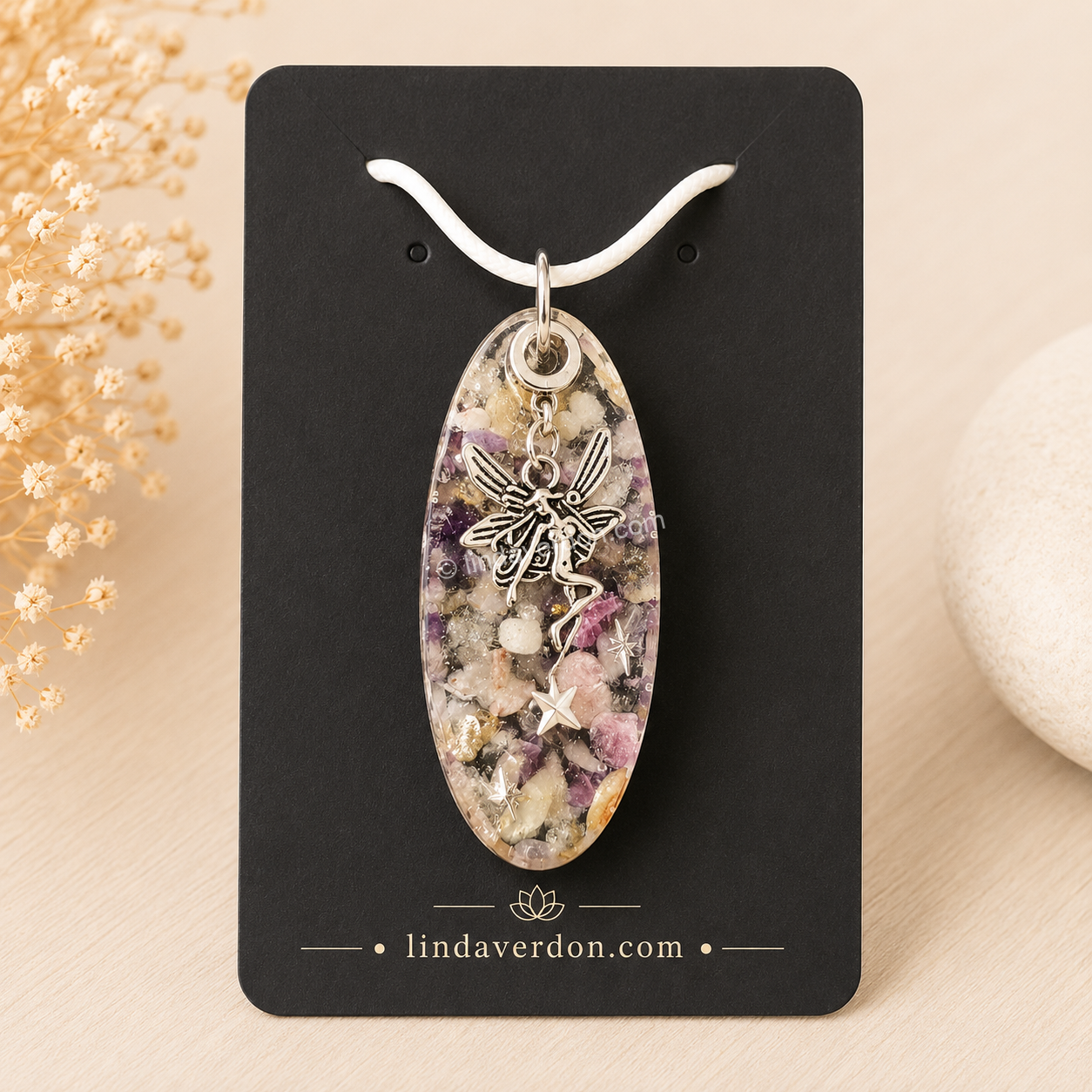 Découvrez ce pendentif Rhodonite Améthyste réalisé à la main en résine époxy avec une fée argentée. Une création artisanale unique préparée avec soin dans l'univers de Linda Verdon.