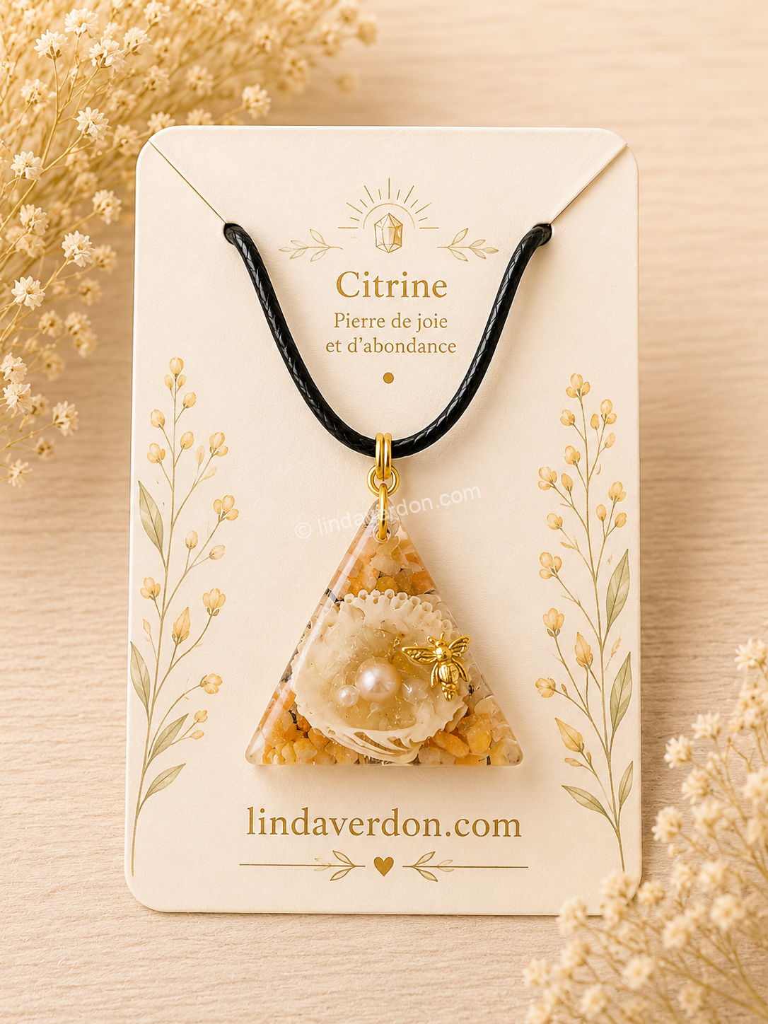 Découvrez ce Pendentif Triangle en Citrine et Cornaline, une création artisanale réalisée à la main en résine époxy. Ce bijou unique renferme une coquille naturelle, une perle d'eau douce, de véritables éclats de citrine et de cornaline, sublimés par une délicate abeille dorée, symbole de prospérité et d'harmonie. Livré avec son cordon.