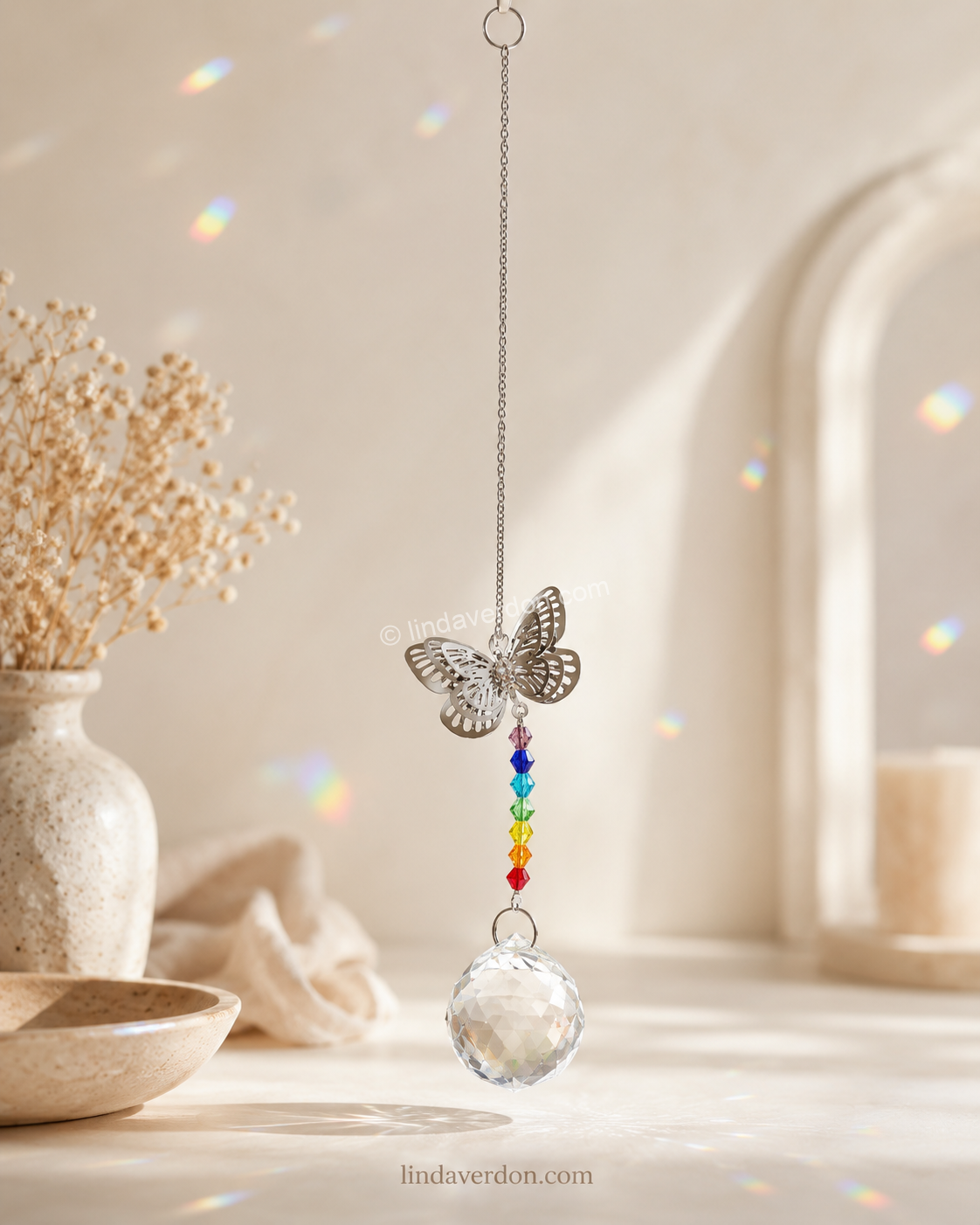 Découvrez ce capteur de lumière Papillon avec 7 chakras et boule facettée en cristal de roche, conçu pour créer de magnifiques reflets au soleil.